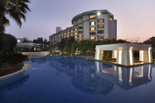 a large swimming pool with a building in the background at Ramada Plaza by Wyndham JHV Varanasi in Varanasi