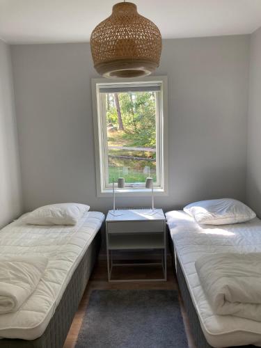 two twin beds in a room with a window at Stora Frögården in Mörbylånga