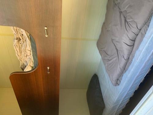 a bedroom with a bed and a wooden cabinet at Mobil-home 4 Pers avec Terrasse à Limeuil - API-1-52-553 in Limeuil