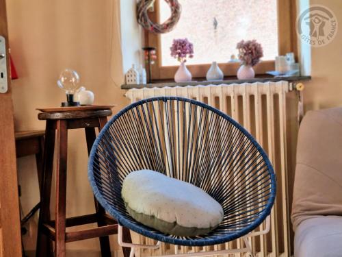 a blue chair with a pillow in a living room at Gîte paisible avec jardin privé, cheminée et équipements modernes au cœur du Parc Naturel de l'Avesnois - FR-1-510-98 in Choisies