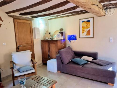 a living room with a couch and a chair at Gîte paisible avec jardin privé, cheminée et équipements modernes au cœur du Parc Naturel de l'Avesnois - FR-1-510-98 in Choisies