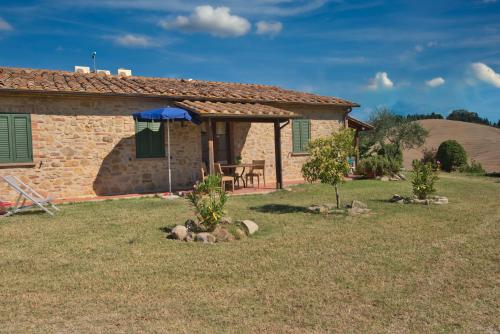 a stone house with a table in a yard at Agriturismo Pelagaccio in Peccioli