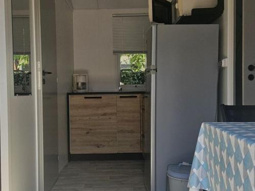 a kitchen with a refrigerator in a room at Mobil Home avec Terrasse - 3 couchages à Notre-Dame-de-Monts - API-1-52-605 in Notre-Dame-de-Monts