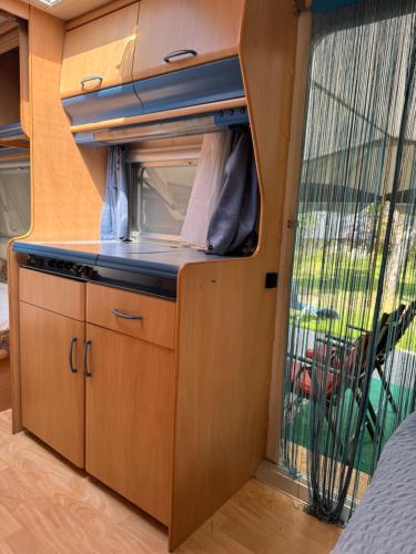 an interior view of a kitchen in an rv at Camping Relaxing im Garten in Wettringen