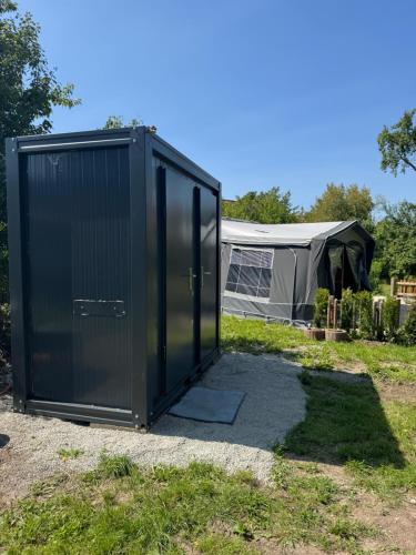 a large black container in front of a tent at Camping Relaxing im Garten in Wettringen