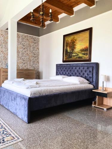 a bedroom with a large bed with a blue headboard at Rezydencja Gołębiówka Mazury in Targowo
