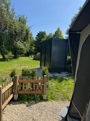 a tent and a bench next to a fence at Camping Relaxing im Garten in Wettringen