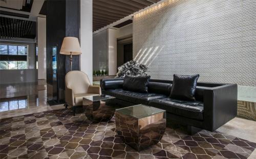 a living room with a black leather couch and a table at Park Hyatt Abu Dhabi Hotel and Villas in Abu Dhabi
