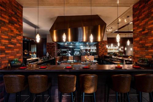 a restaurant with a bar with stools and a kitchen at Park Hyatt Abu Dhabi Hotel and Villas in Abu Dhabi