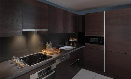a kitchen with brown cabinets and a stove top oven at Park Hyatt Abu Dhabi Hotel and Villas in Abu Dhabi