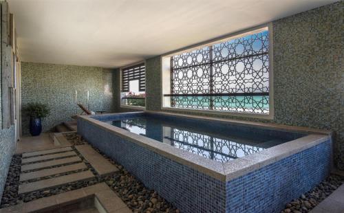 a swimming pool in a house with a window at Park Hyatt Abu Dhabi Hotel and Villas in Abu Dhabi