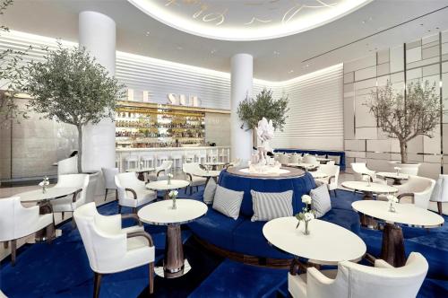 a restaurant with white tables and white chairs at Hôtel Martinez, in The Unbound Collection by Hyatt in Cannes