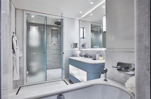 a bathroom with a tub and a sink and a shower at Hôtel Martinez, in The Unbound Collection by Hyatt in Cannes