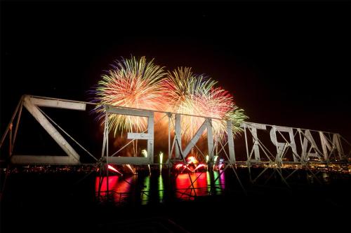 a fireworks display over a bridge over water at night at Hôtel Martinez, in The Unbound Collection by Hyatt in Cannes