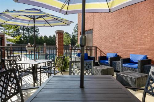 a patio with tables and chairs and umbrellas at Hyatt Place Memphis Germantown in Memphis