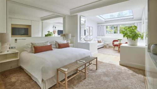 a bedroom with a large bed and a living room at Hôtel Martinez, in The Unbound Collection by Hyatt in Cannes