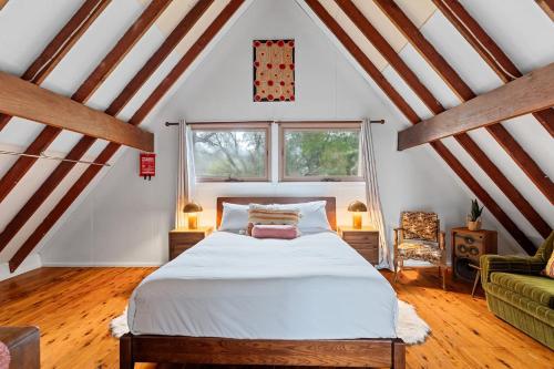 a bedroom with a large bed in a attic at 'The Aerie' Bushland A-frame Escape with Retro Charm in Katoomba