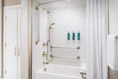 a bathroom with a shower and a bath tub at Hilton Charlotte University Place in Charlotte