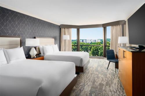 a hotel room with two beds and a window at Hilton Charlotte University Place in Charlotte