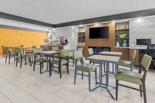 a restaurant with tables and chairs and a tv at La Quinta Inn by Wyndham Huntsville Research Park in Huntsville
