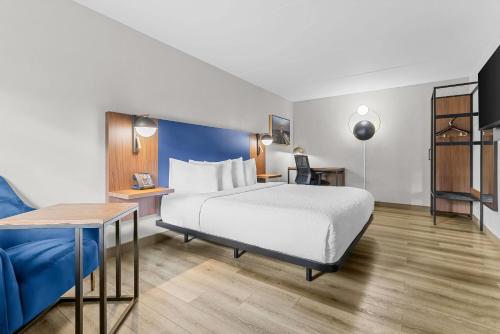 a hotel room with a bed and a blue couch at La Quinta Inn by Wyndham Huntsville Research Park in Huntsville