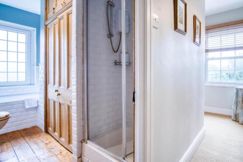 a bathroom with a shower with a glass door at Bwthyn Berwig - 3 Bedroom Cottage - Llanrhidian in Swansea