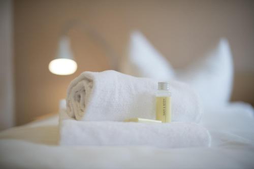 a bottle of soap and towels on a bed at Hôtellerie du Couvent Oberbronn in Oberbronn