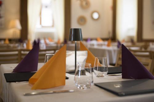 a table with purple and yellow napkins and glasses on it at Hôtellerie du Couvent Oberbronn in Oberbronn