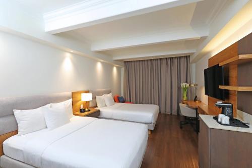 a hotel room with two beds and a television at Clarion Hotel Real Tegucigalpa in Tegucigalpa