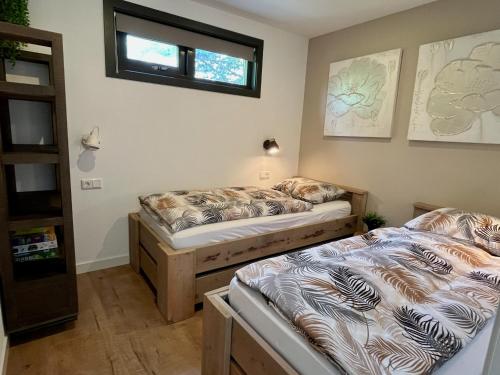 two twin beds in a room with a window at BeachHouse AAN ZEE in Noordwijk aan Zee