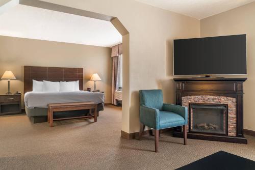 a bedroom with a bed and a fireplace with a television at Quality Inn & Suites Next to the Casino in Ceresco