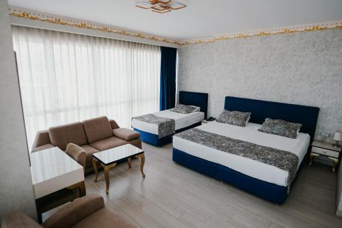 a hotel room with two beds and a couch at Grand Karot Hotel in Yalova