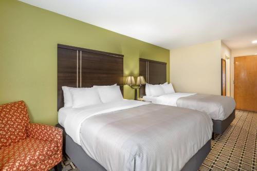 a hotel room with two beds and a chair at Quality Inn West of Asheville in Canton