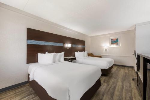 a hotel room with two beds and a television at Quality Inn & Suites Airport in Charlotte