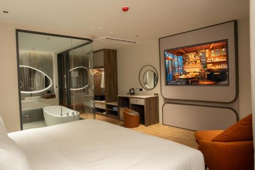 a hotel room with a bed and a bathroom at Richmann Resort Hotel Hatyai in Hat Yai
