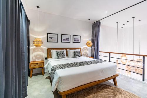 une chambre avec un grand lit et un balcon dans l'établissement Villa Castello di Quassolo, à Canggu