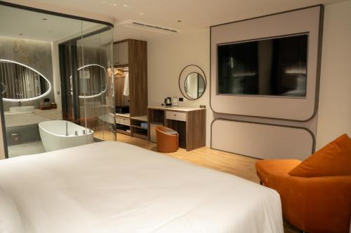 a hotel room with a bed and a bathroom at Richmann Resort Hotel Hatyai in Hat Yai