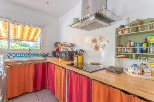 a kitchen with a counter with colorful curtains on it at Peaceful Countryside Getaway in Parbayse