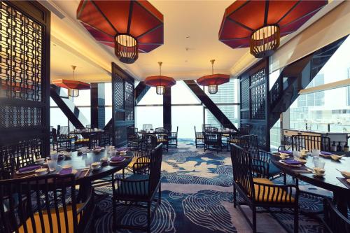 a restaurant with tables and chairs and large windows at Cinnamon Life at City of Dreams in Colombo