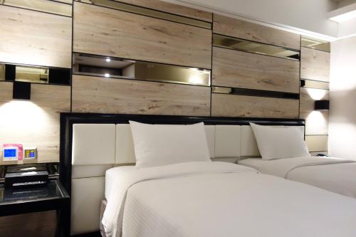 a bedroom with two beds and a wall with wood at The Cloud Hotel in Kaohsiung