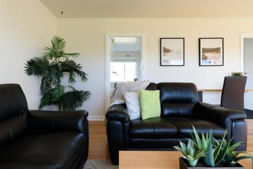 a living room with two chairs and a couch at Simple & Comfortable Coastal Retreat in George Town