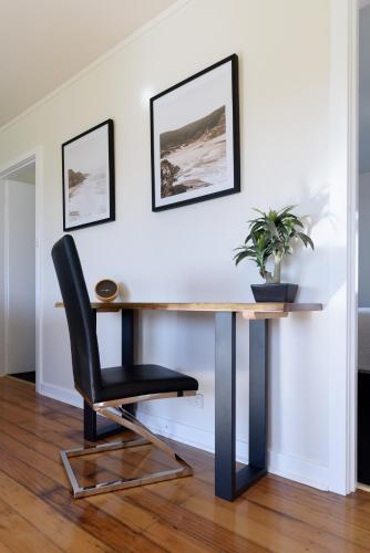 a desk with a black chair and a potted plant at Simple & Comfortable Coastal Retreat in George Town