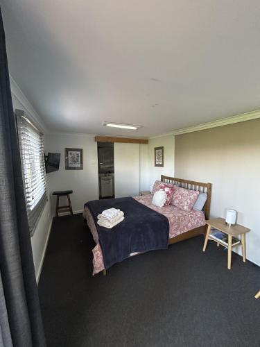 a bedroom with a bed and a table and a window at King River Caravan Park in Whitfield