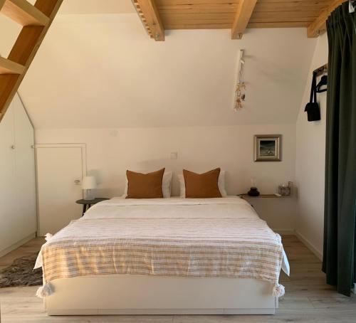 a bedroom with a large white bed with brown pillows at Tri Tresnje & Three Cherries in Grabovnica