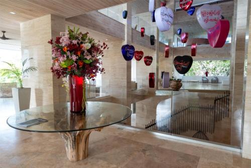 a vase of flowers on a table in a room at Hodges Bay Resort & Spa, an HQ Luxury Resort & Residences in Saint Johnʼs