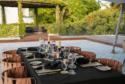 a long table with wine glasses and napkins on it at Hodges Bay Resort & Spa, an HQ Luxury Resort & Residences in Saint Johnʼs
