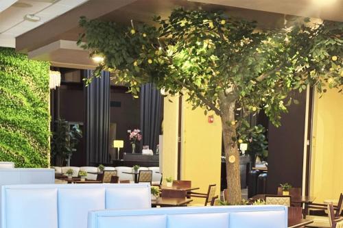 a restaurant with a tree and tables and chairs at Hotel Gurnee in Gurnee