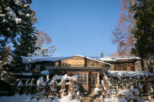 a house covered in snow with a sign on it at LAMP Nojiriko The Sauna by the Lake in Shinano