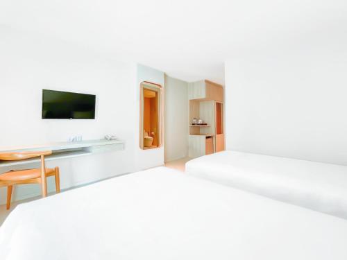 a hotel room with a bed and a desk at Zand Morada Pattaya in Jomtien Beach