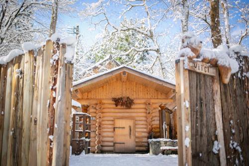 a log cabin in the snow with a fence at LAMP Nojiriko The Sauna by the Lake in Shinano